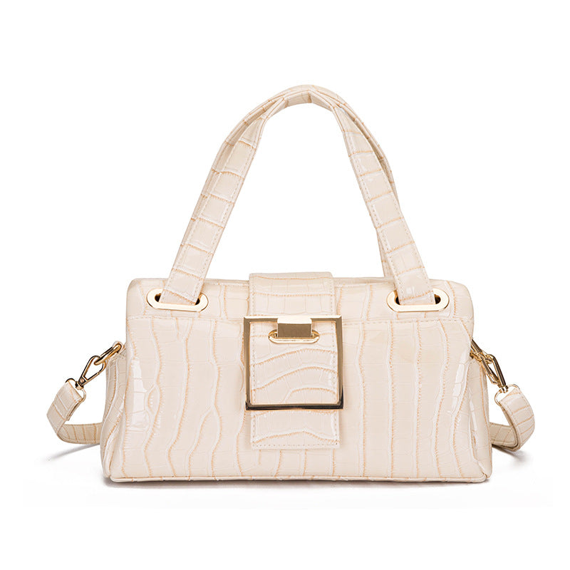 Cream beige crocodile texture handbag with gold buckle and detachable strap on white background