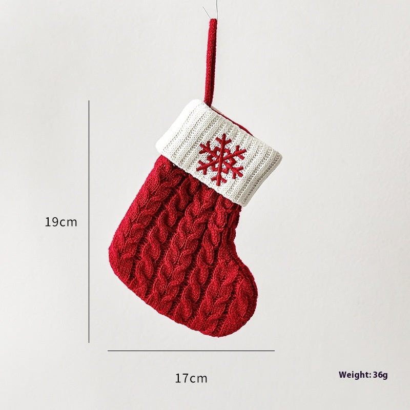 Red knit Christmas stocking with white cuff and snowflake design, hanging with size and weight details