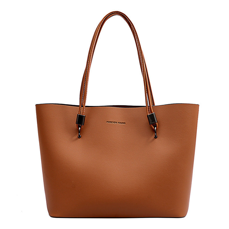 Brown leather tote bag with double handles and Forever Young logo on front