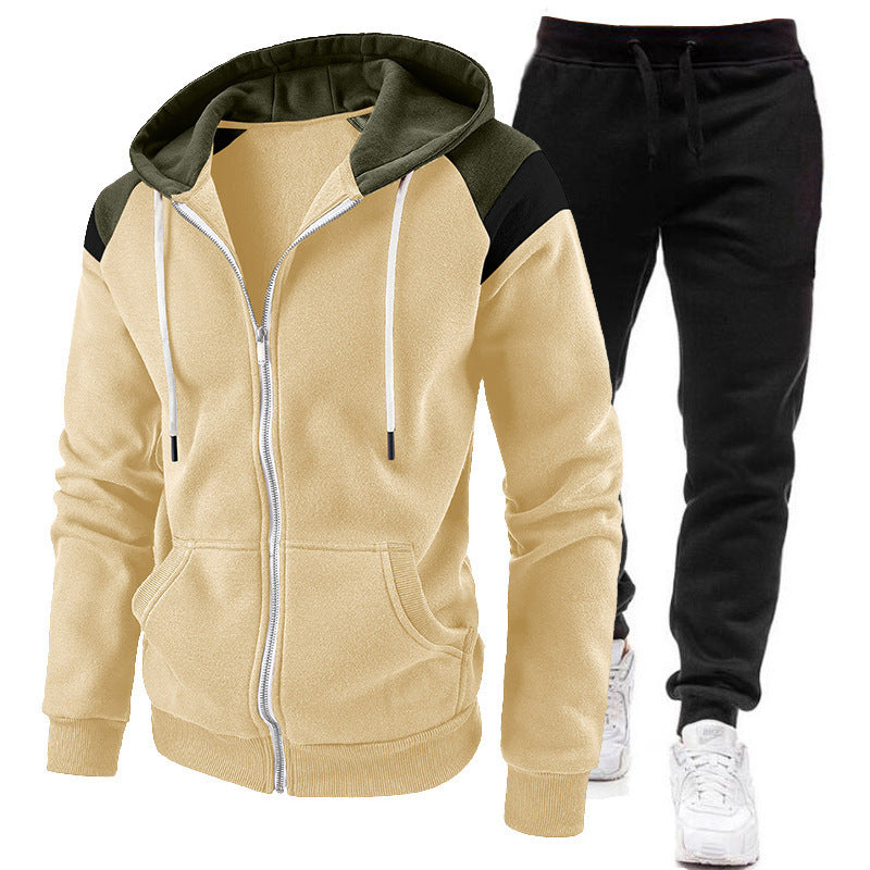 Beige zip-up hoodie with olive green and black accents and black jogger pants with white sneakers