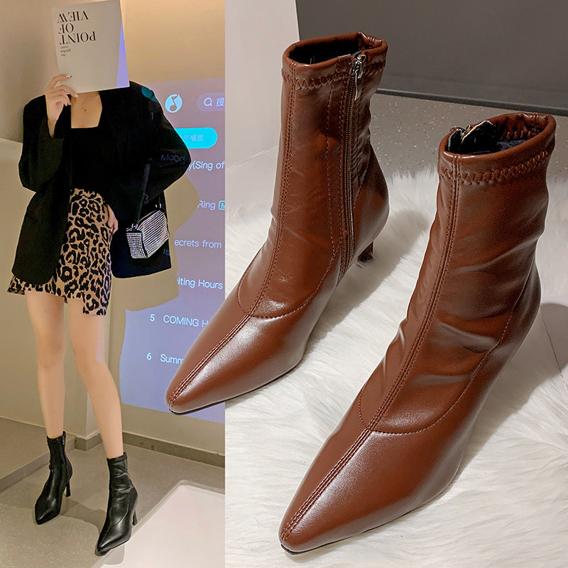 Brown leather ankle boots with side zipper and pointed toe on white fur, styled with black blazer and leopard skirt