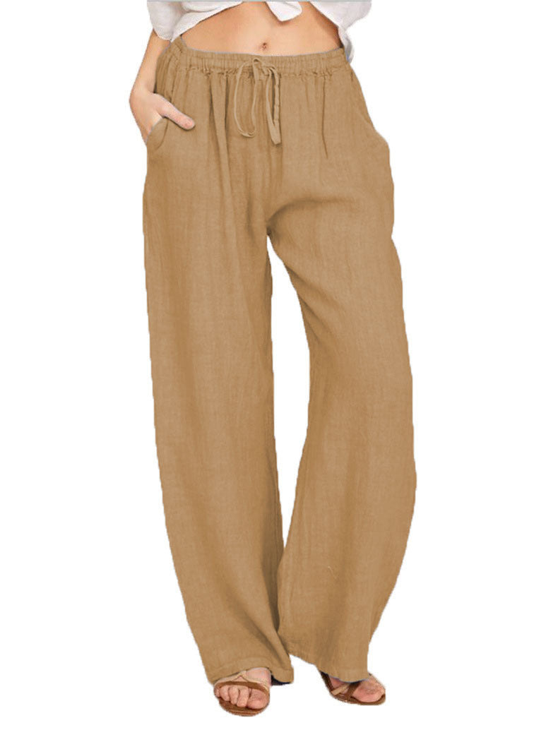 Woman wearing loose camel brown linen drawstring pants with side pockets and sandals