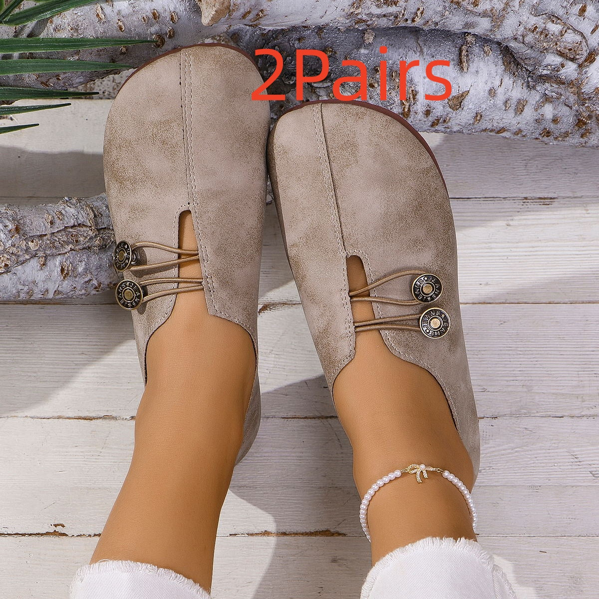 Women's beige suede slip-on shoes with button elastic detail on wooden floor