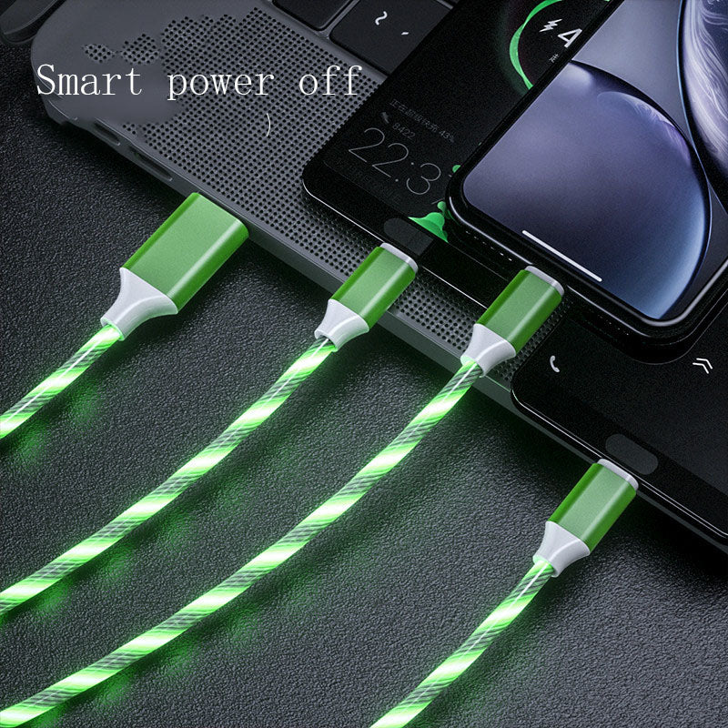 Green LED flowing charging cables connected to multiple smartphones and a laptop keyboard on a black surface