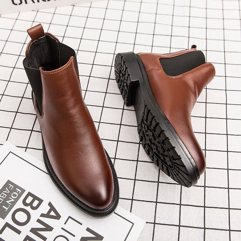 Pair of brown leather Chelsea boots with black elastic side panels on checkered background