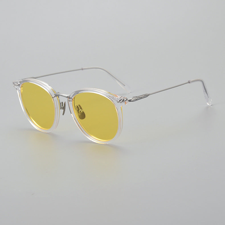 Round yellow lens sunglasses with transparent frame and thin metal arms on gray background