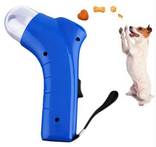 Blue pet treat launcher with ergonomic grip firing treats to a small standing dog