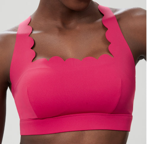 Plus size women's hot pink sports bra with scalloped edges and seamless design