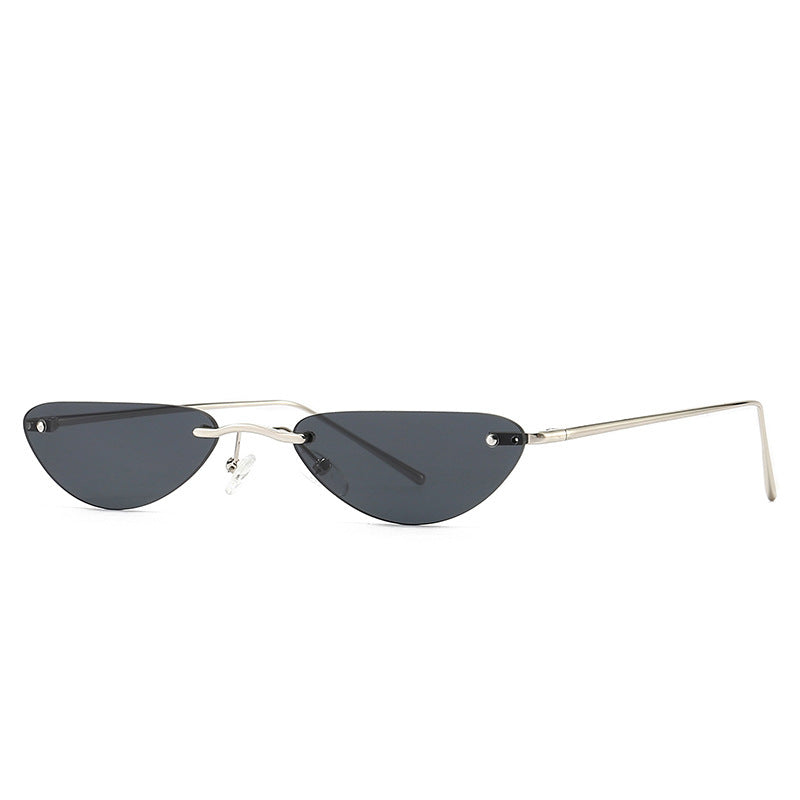 Cat eye sunglasses with narrow dark lenses and thin silver metal frame on white background