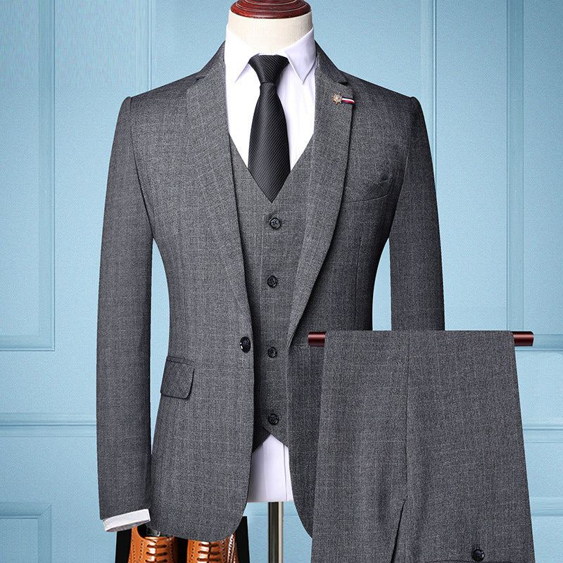 Gray men's three-piece formal suit with black tie, white shirt, and matching trousers on mannequin