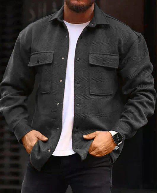 Man wearing a black polyester men's polo collar casual jacket with long sleeves and flap chest pockets