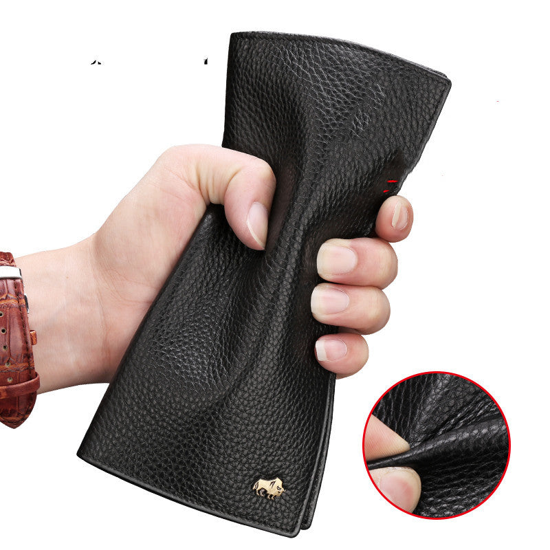 Black pebbled leather wallet held in hand with small gold bison logo, showing durable texture