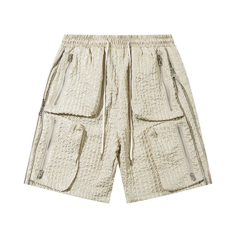 Beige men's loose workwear shorts with four large zippered pockets and textured fabric