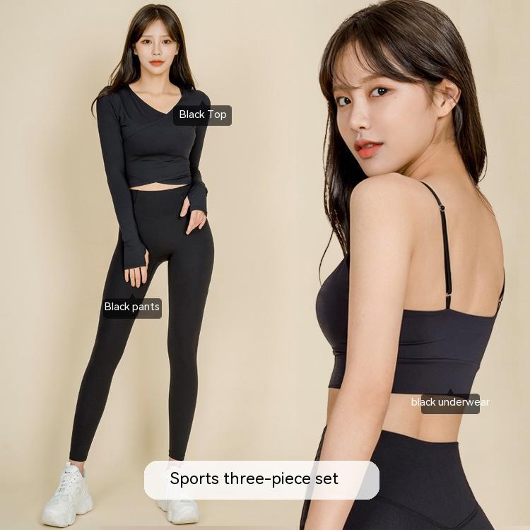 Woman wearing black sports three-piece set with long sleeve top, leggings, and strappy crop top activewear