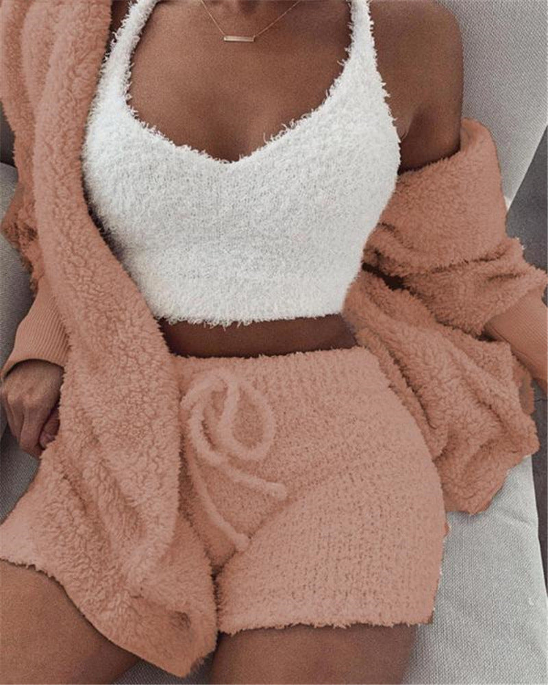 woman wearing white fuzzy crop top and pink sherpa jacket with matching drawstring shorts cozy loungewear