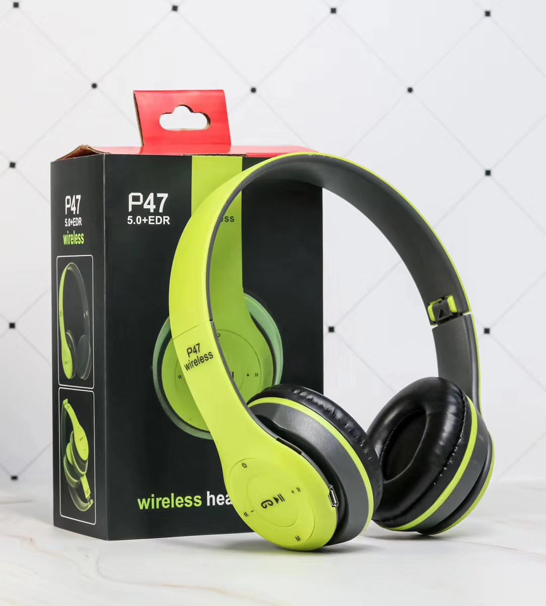 Green and black P47 wireless Bluetooth headphones with packaging box on white tiled background