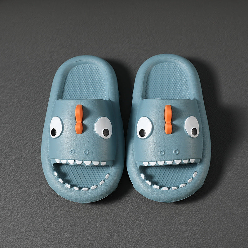Blue kids shark slippers with orange fin and white teeth on gray background