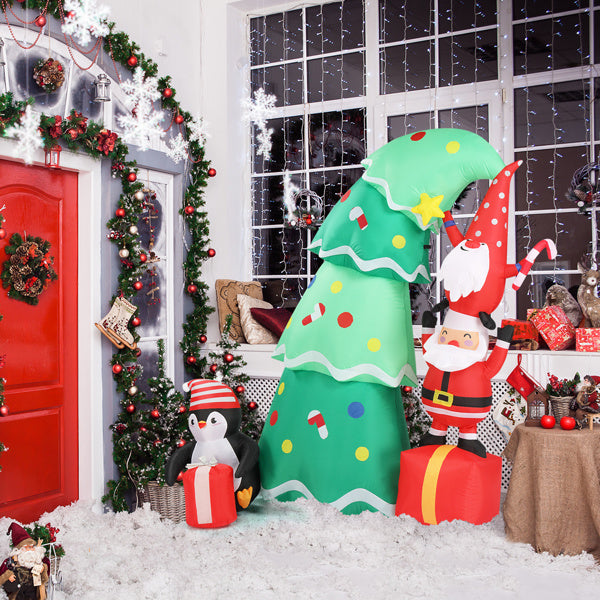 Indoor Christmas scene with inflatable Santa, penguin, decorated green tree, red door, and holiday garlands
