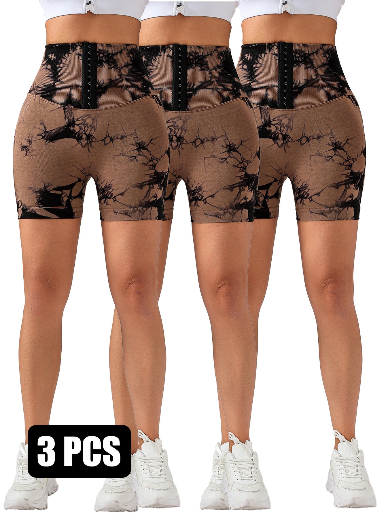 Three women wearing high-waisted brown and black tie-dye scrunch butt lifting shorts with white sneakers