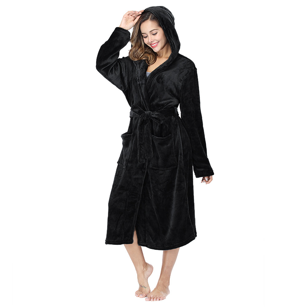 Woman wearing black plush fleece hooded robe with pockets and belt, standing barefoot