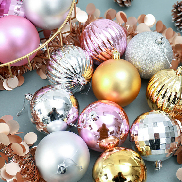 Shiny metallic Christmas baubles in silver, gold, pink, and rose gold with sequined garland on gray surface