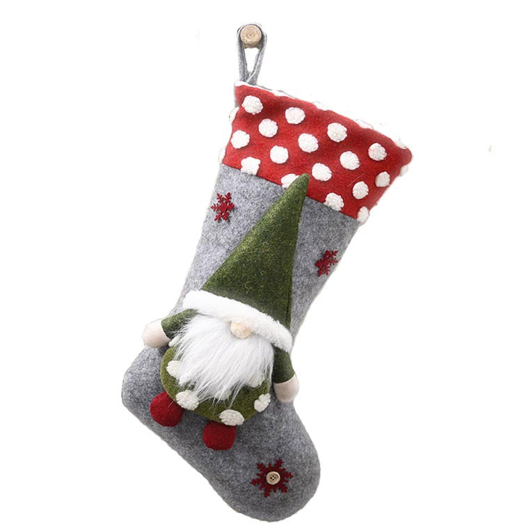 Christmas stocking with red and white polka dot cuff, gray body, and plush gnome decoration