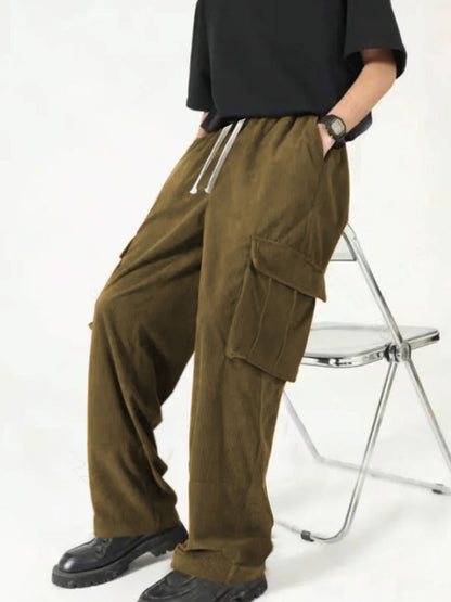 Person wearing brown cargo pants with drawstring and black shoes sitting on a metal folding chair