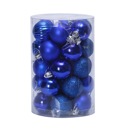 Clear cylindrical container filled with assorted shiny and glittery blue Christmas ornaments