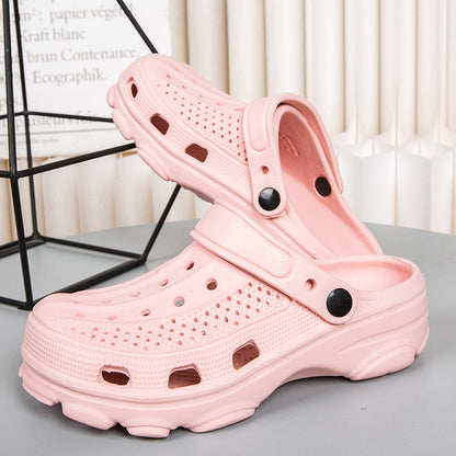 Pair of light pink ventilated rubber clogs with adjustable heel straps on gray surface