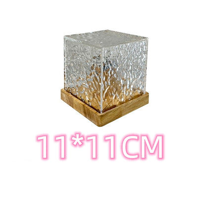 Textured clear glass cube with wooden base measuring 11 by 11 cm on white background