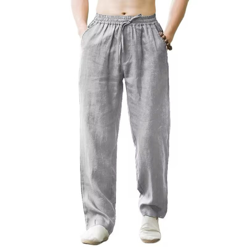 Front view of a man wearing light gray loose linen pants with elastic waist and drawstring