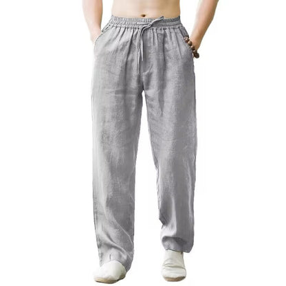 Front view of a man wearing light gray loose linen pants with elastic waist and drawstring