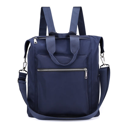 Navy blue backpack tote bag with front zip pocket, dual shoulder straps, and detachable crossbody strap
