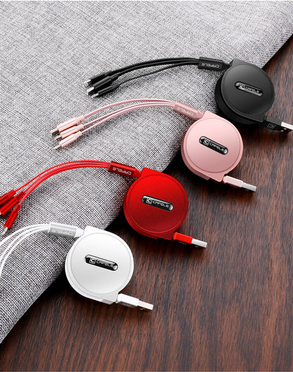Four Cafele retractable multi-charging cables in black, pink, red, and white on wood and fabric surface