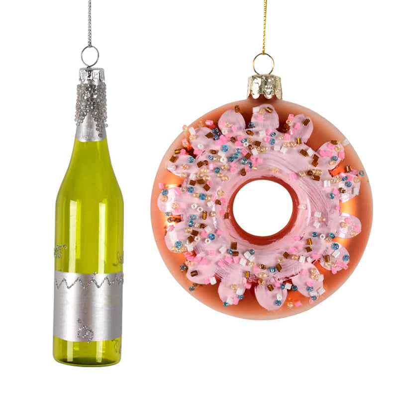 Christmas ornaments shaped like a green bottle and a pink frosted donut with colorful sprinkles