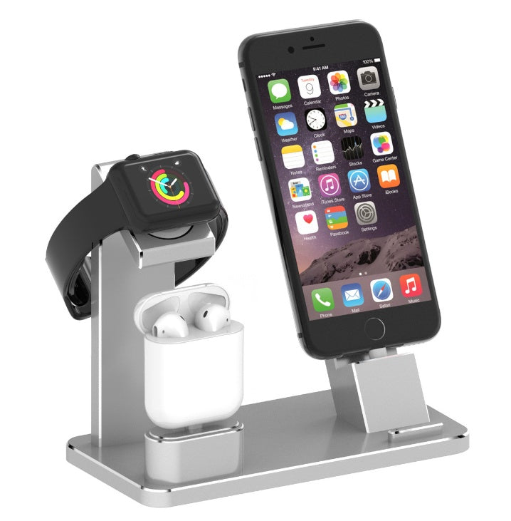Silver multi-device charging stand holding a smartwatch, wireless earbuds, and a smartphone