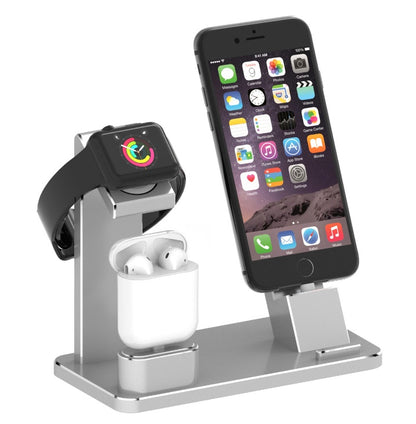 Silver multi-device charging stand holding a smartwatch, wireless earbuds, and a smartphone