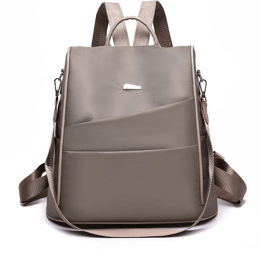Minimalist taupe backpack with multiple compartments and adjustable straps on white background