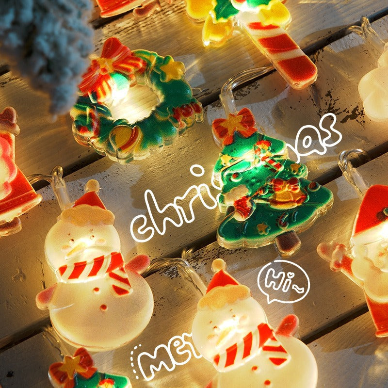Bright Christmas string lights shaped like snowmen, wreaths, candy canes, and Christmas trees on wooden background