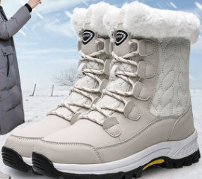 Stylish beige winter boots with synthetic fur lining and durable rubber soles on snowy background