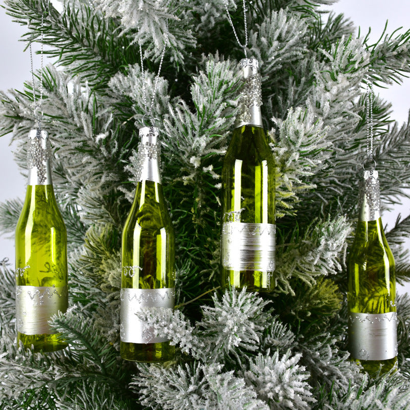 Frosted pine branches with hanging green bottles decorated as Christmas tree ornaments