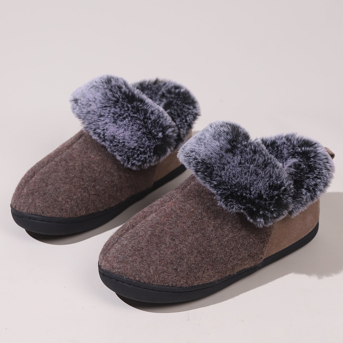 brown wool slippers with thick gray faux fur lining and black soles on light background