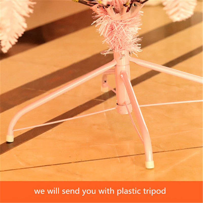 Close-up of a pink metal tripod stand with plastic foot caps on tiled floor