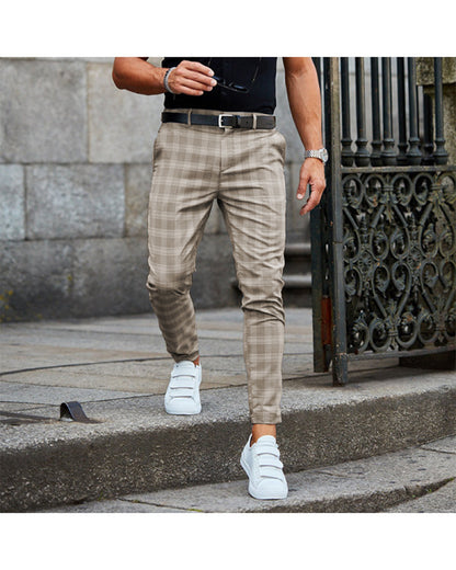 Man wearing beige plaid pants, black belt, white velcro sneakers, and black shirt walking on stone steps