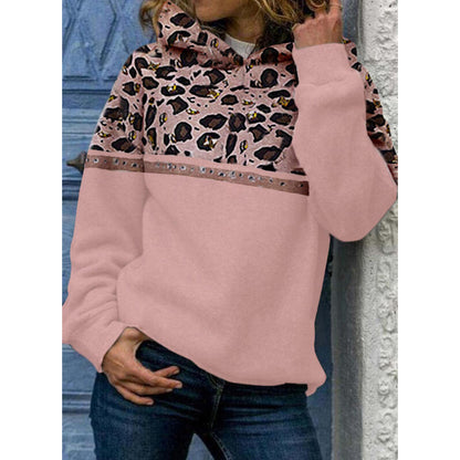 Woman wearing pink hoodie with leopard print and studded details, paired with blue jeans