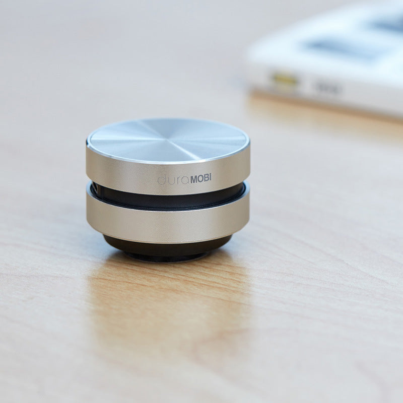 duramobi gold and black round desktop phone stand on wooden table