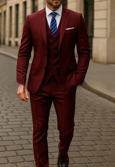 Man wearing a tailored burgundy three-piece suit with a white shirt and blue striped tie walking on a city street