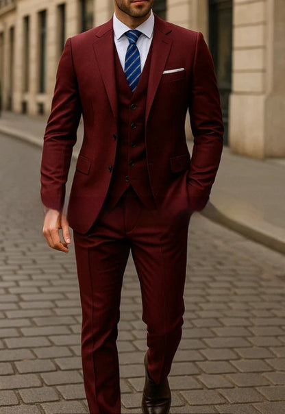 Man wearing a tailored burgundy three-piece suit with a white shirt and blue striped tie walking on a city street