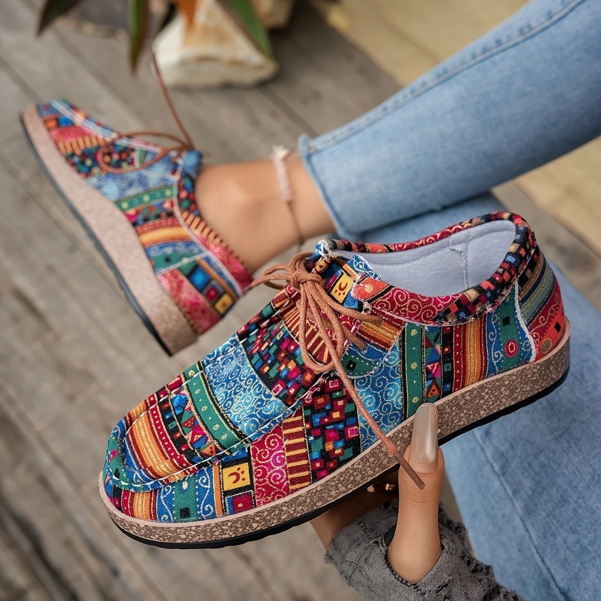Colorful bohemian patterned casual shoes with cork soles, worn with light blue jeans