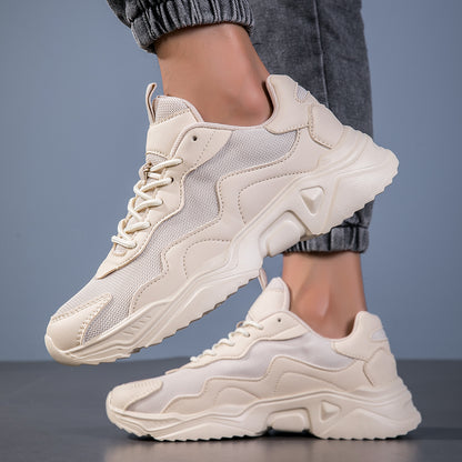 Close-up of beige chunky sneakers with mesh and leather details worn with rolled gray pants